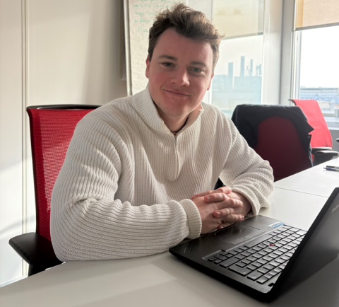 Le visuel est une photo portrait de Vivien, assis à son bureau.